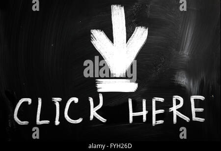 Cliquez ici à la main avec craie blanche sur un tableau noir Banque D'Images