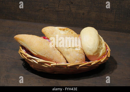 Différents types de pains, gâteaux, bun, dans un panier, sur une surface en bois, rustique Banque D'Images