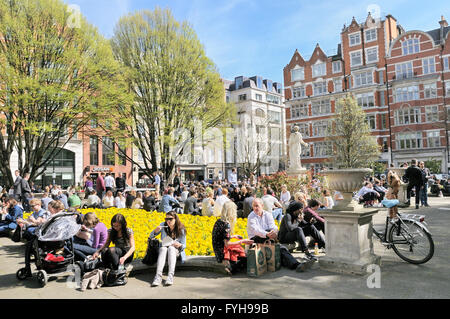 Les gens se détendre sur une journée ensoleillée dans Golden Square, Soho, City of Westminster, London, England, UK Banque D'Images