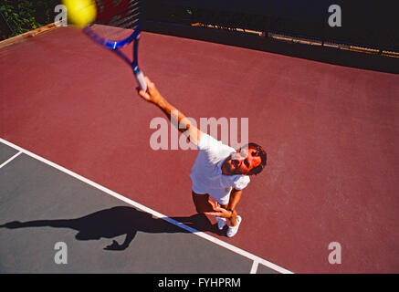 Vue supérieure de l'homme joueur de tennis frapper la balle avec une raquette