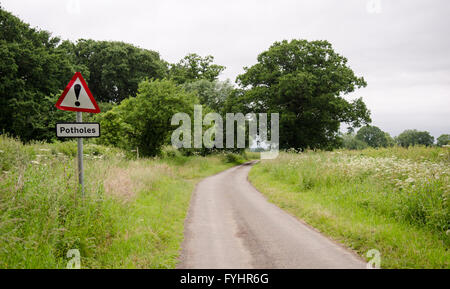 Un signe à côté d'une seule piste country lane avertissement de route de poule. Banque D'Images