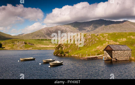 Bateaux amarrés sur un petit lac près de Rhyd Ddu, avec Snowdon Mountain derrière, dans le parc national de Snowdonia dans le nord du Pays de Galles. Banque D'Images
