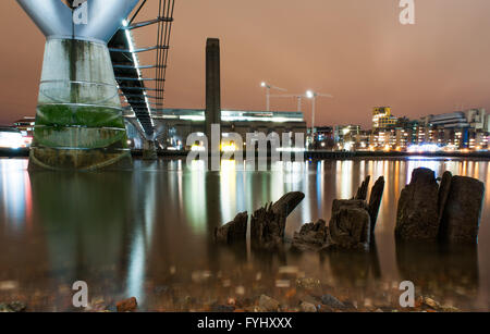 Londres, Angleterre - 2 décembre 2010 : Le Millennium Bridge et la Tate modern vu depuis les rives de la tamise de nuit. Banque D'Images