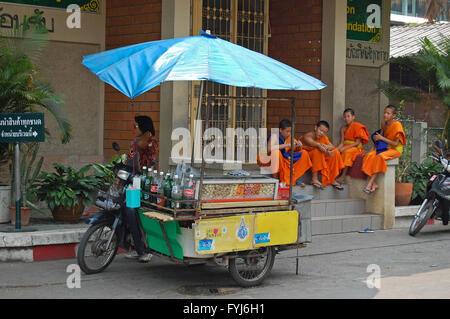 Jeunes moines du Wat Phra Singh de chiang mai vous détendre dans leurs robes oragne comme ils discuter entre eux Banque D'Images