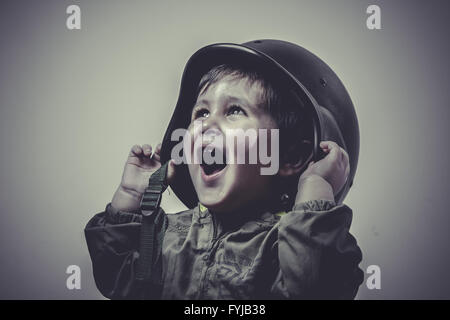 Uniforme, fun et drôle enfant vêtus de chapeau militaire, jouant des jeux de guerre Banque D'Images