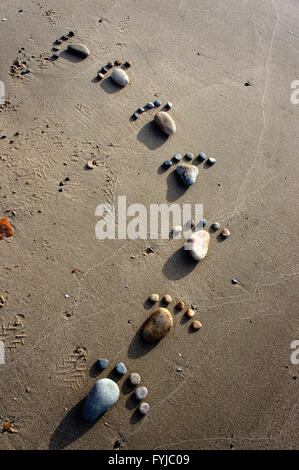 Groupe de pied par galet sur fond de sable, une notion de pierre avec des couleurs jaune, sur la plage, super produit art Banque D'Images