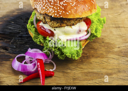 Hamburger délicieux avec des légumes sur la table en bois Banque D'Images