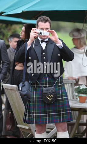 Un homme portant un kilt de prendre des photographies à un mariage avec un appareil photo numérique compact, Banque D'Images