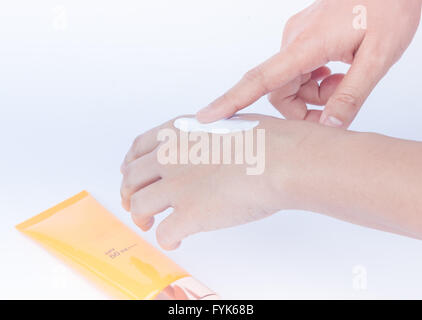 Woman pouring lotion pour le corps sur la main sur fond blanc Banque D'Images