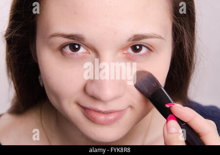 Maquilleur est ombragée pinceau sur modèle visage Banque D'Images