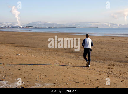 Jogger fonctionnant sur une plage Banque D'Images