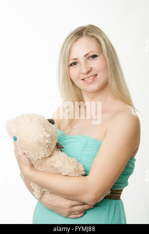 La fille enceinte serrant un ours en peluche Banque D'Images