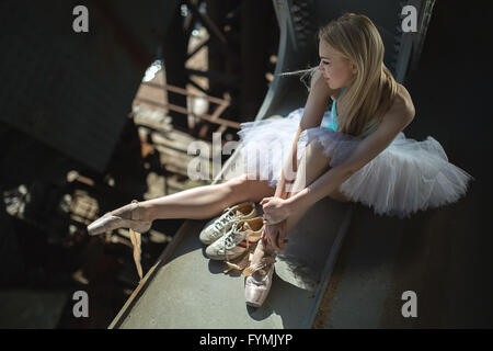 Ballerine assise sur le bord du pont Banque D'Images