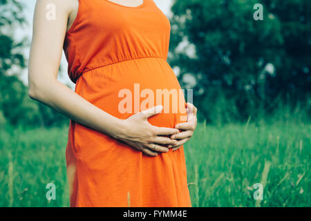 Femme enceinte mit ses mains sur son ventre Banque D'Images