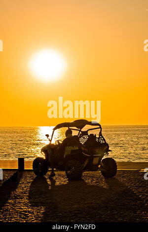 Moto Quad par la mer au coucher du soleil Banque D'Images