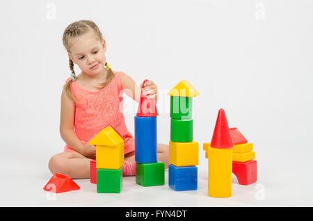 La jeune fille met sur une tour de cubes de maison Banque D'Images