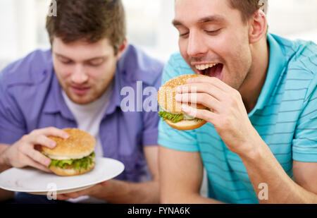 Close up of friends eating hamburgers à la maison Banque D'Images