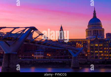 Vue panoramique sur le coucher du soleil pourpre à la Cathédrale St Paul et le Millennium Bridge à Londres avec des gens qui marchent dans blurred motion Banque D'Images