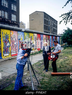 Août 1986, une équipe de télévision CBS une entrevue en face de Mur décoré de fresques de la Statue de la liberté, côté ouest de Berlin, Allemagne, Europe, Banque D'Images