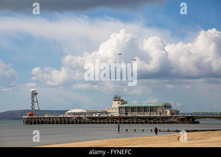 Les avions volant au-dessus de la plage de Bournemouth et de la jetée sur un jour de tempête en Avril Banque D'Images