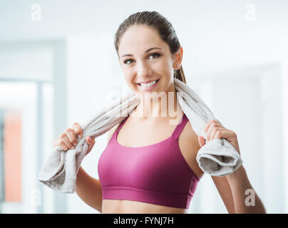 Belle femme sportive avec sèche-serviettes dans la salle de sport de détente après l'entraînement, le mode de vie sain et fitness concept Banque D'Images