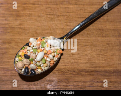Toutes sortes de légumes à l'intérieur d'une cuillère sur une planche à découper en bois Banque D'Images