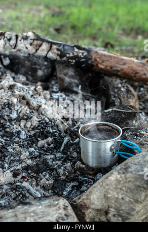 Faire le café sur feu de bois dans la forêt. Banque D'Images