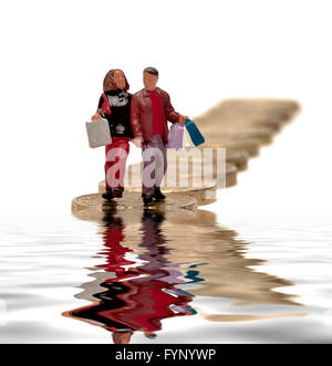 Un petit couple carrying shopping bags walking sur pièces livre avec un compte numérique piscine d'eau. Banque D'Images