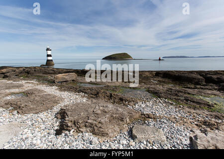 Vue pittoresque de Penmon Point Lighthouse, avec le détroit de Menai et île de macareux dans l'arrière-plan. Banque D'Images