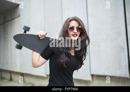 Adolescent élégant fille avec un longboard Banque D'Images