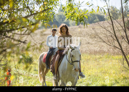 Jeune couple amoureux riding a horse Banque D'Images