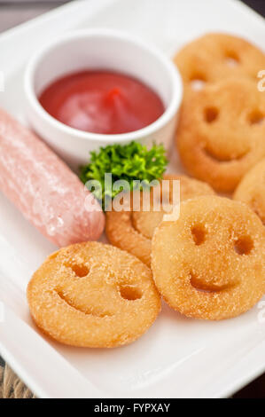 Les saucisses avec des pommes de terre en souriant Banque D'Images