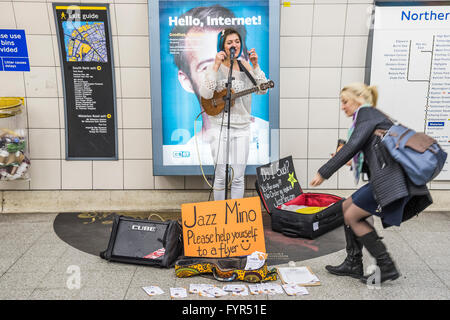 Mino Jazz chante et joue le ukulele comme elle busks pour les passagers passant par la station de métro Waterloo, Londres. Elle est Banque D'Images