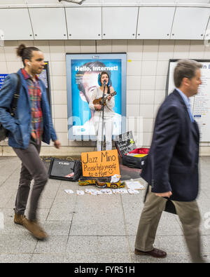 Mino Jazz chante et joue le ukulele comme elle busks pour les passagers passant par la station de métro Waterloo, Londres. Elle est Banque D'Images