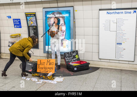 Mino Jazz chante et joue le ukulele comme elle busks pour les passagers passant par la station de métro Waterloo, Londres. Elle est Banque D'Images