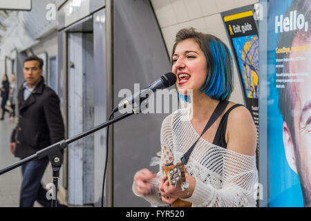 Mino Jazz chante et joue le ukulele comme elle busks pour les passagers passant par la station de métro Waterloo, Londres. Elle est Banque D'Images