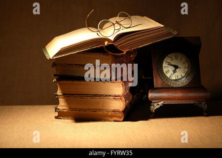 Vintage still life avec de vieux livres et spectacles près de réveil Banque D'Images