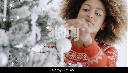 Pretty young woman decorating a Christmas Tree Banque D'Images