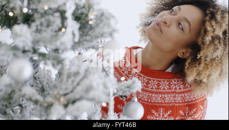 Pretty young woman decorating a Christmas Tree Banque D'Images