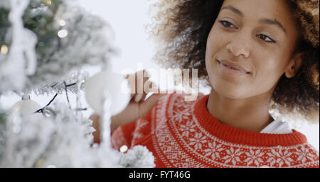 Pretty young woman decorating a Christmas Tree Banque D'Images