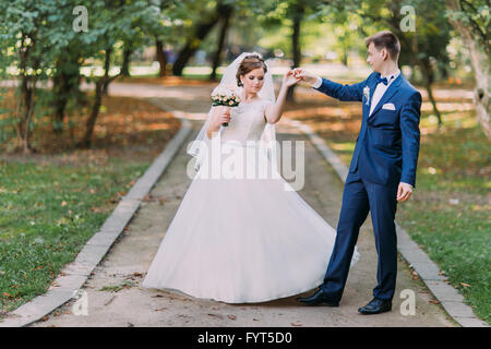 Happy wedding couple charmant époux et épouse brunet dancing in park Banque D'Images