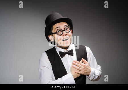 Jeune homme en gilet noir classique et un chapeau contre gray Banque D'Images