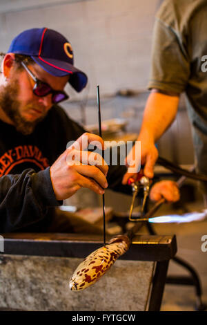 Dans un studio de verre soufflé sur l'île de Whidbey, WA, un homme fait une sculpture en verre. Banque D'Images