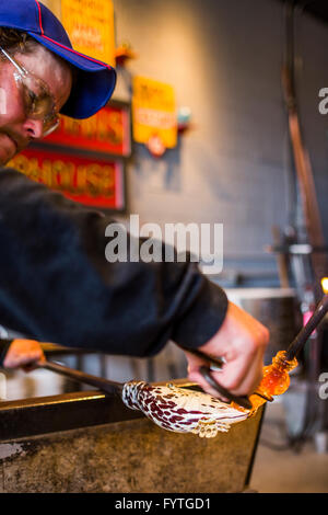 Dans un studio de verre soufflé sur l'île de Whidbey, WA, un homme fait une sculpture en verre. Banque D'Images