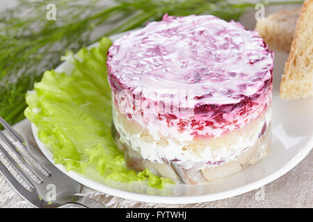 Salade 'Hareng sous un manteau de fourrure'sur une plaque blanche Banque D'Images