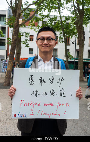 Montreuil, France, AIDES ONG française, campagne contre la discrimination homophobie, IDAHOT, "la Journée internationale contre l'homophobie, la transphobie et la biphobie" activisme, Chinois Homme tenant affiche de protestation "Protégez votre famille contre l'homophobie" campagne pour l'égalité homosexuelle, manifestations d'immigrants, étiquette des droits des gays Banque D'Images