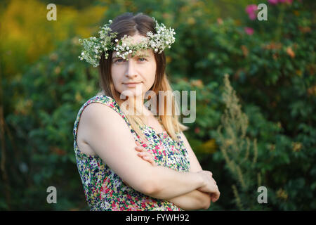 Jolie jeune femme avec couronne de fleurs sur la tête Banque D'Images