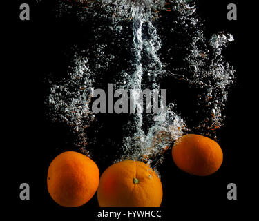 Les oranges tomber dans l'eau Banque D'Images