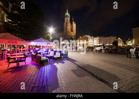 Nuit dans la ville de Cracovie, Pologne, Place de la vieille ville, terrasse d'un café, restaurant, transport de chevaux, entraîneurs, rue pavée, ce lieu historique Banque D'Images