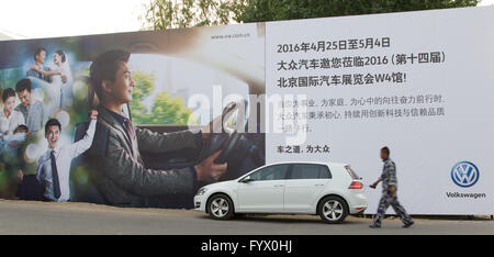 Beijing, Chine. Apr 24, 2016. Un VW Golf est vu sur une rue pendant le Salon Auto China de Pékin, Chine, 24 avril 2016. Dans l'arrière-plan une Volkswagen billboard. Photo : Friso Gentsch/dpa/Alamy Live News Banque D'Images